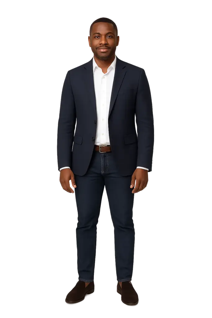 Full-body portrait of Tunde Adesina, Nigerian media editor, wearing a navy blazer, white shirt, and jeans, standing confidently.
